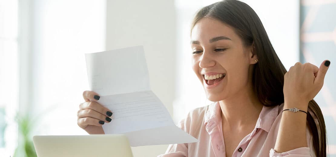 Happy young woman excited by reading good news in letter